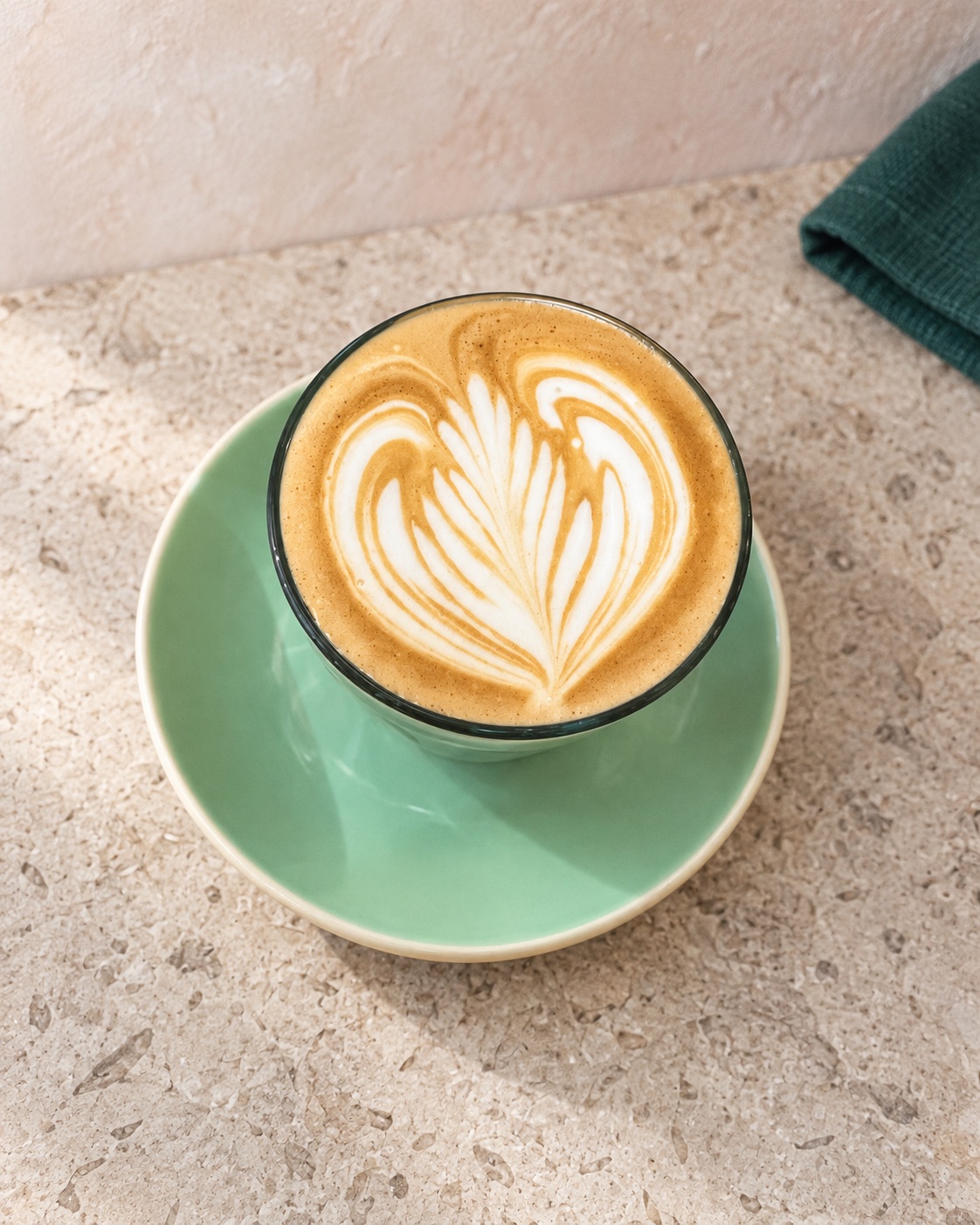 Café latte served on a green saucer